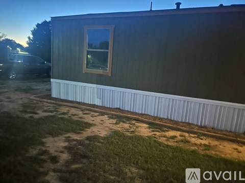A house with a grey siding and a white fence is shown.