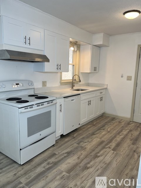 A kitchen with white appliances and cabinets.