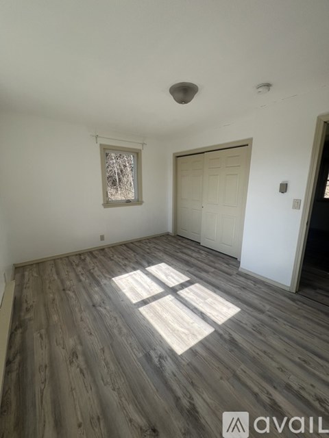 A room with wooden flooring and a white door.