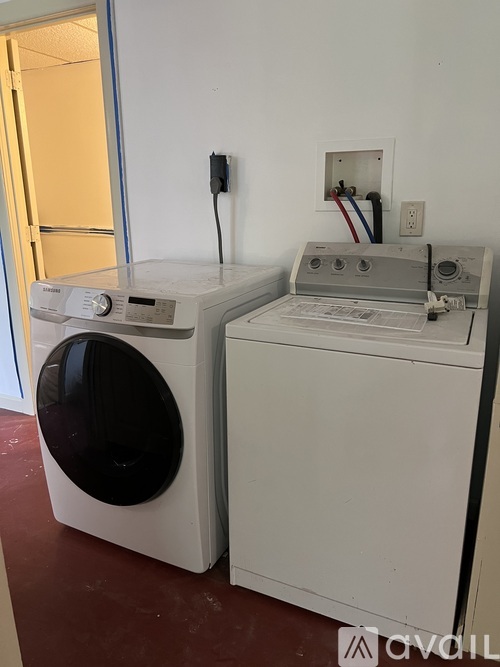 A white washing machine and dryer are sitting next to each other.