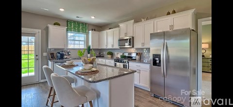 A kitchen with white cabinets and a granite countertop.