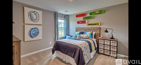 A bedroom with a bed, nightstand, and two paintings on the wall.