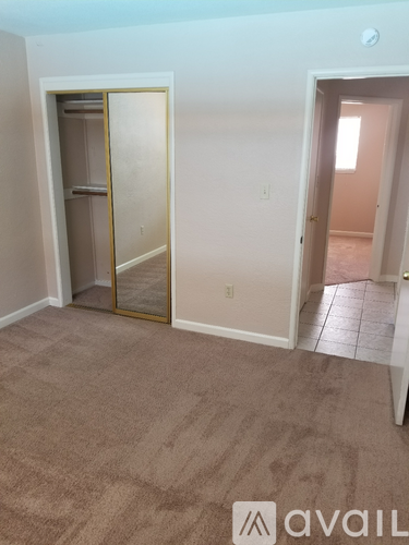 A room with a carpeted floor and a doorway leading to another room.