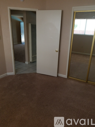 A room with a carpeted floor and a white door.