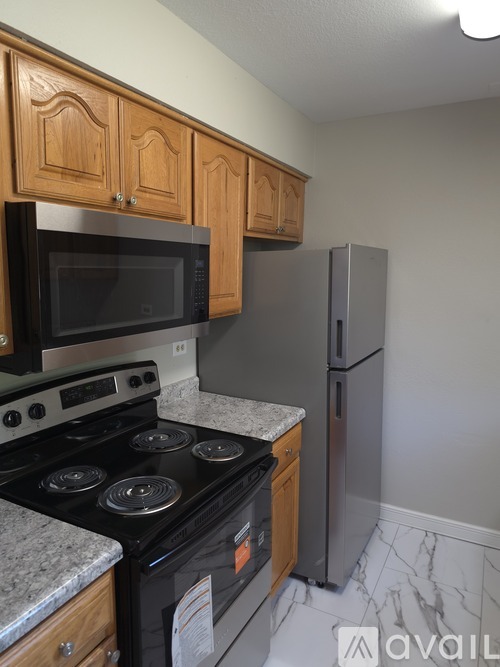 A kitchen with a black stove top oven and a black microwave above it.
