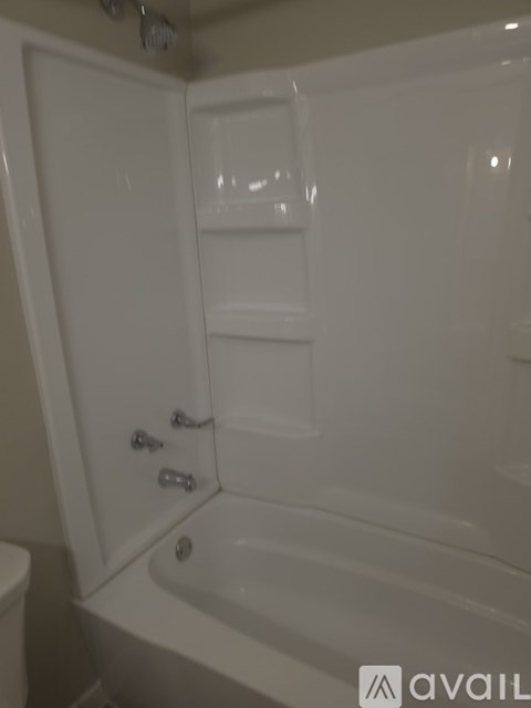 A white bathroom with a tub and toilet.