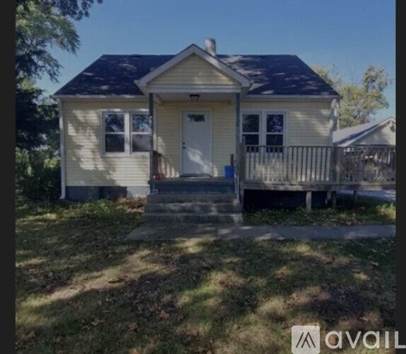 A small house with a porch and a blue door.