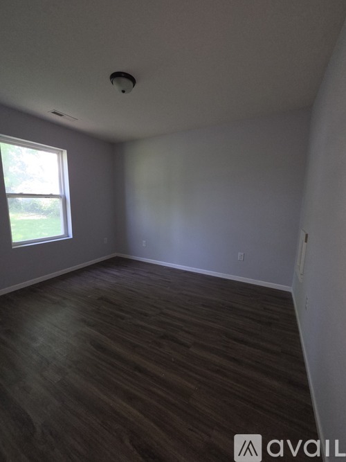 A room with a window and a ceiling fan.