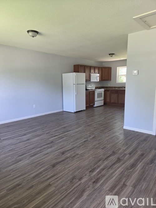 A kitchen with a white refrigerator and wooden cabinets.