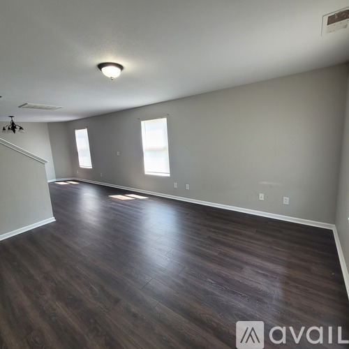 A room with wooden flooring and a window.