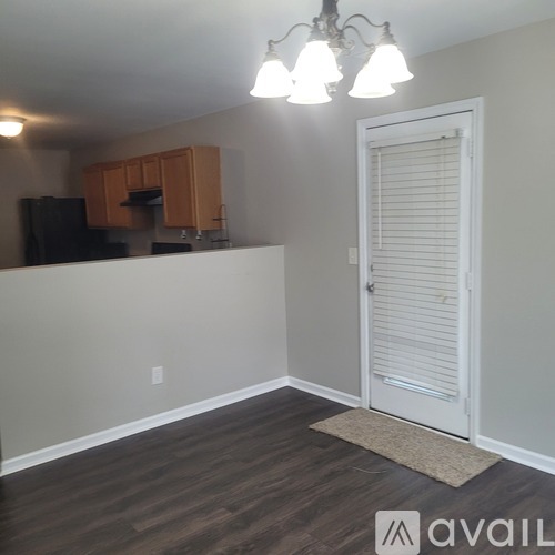 A kitchen area with wooden cabinets and a black refrigerator.
