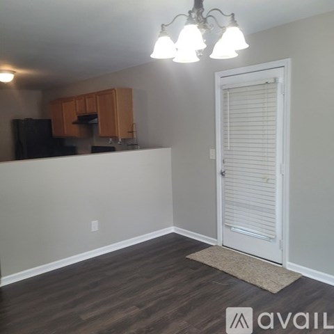 A kitchen area with wooden cabinets and a black refrigerator.
