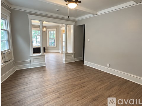 A spacious room with wooden floors and white walls.