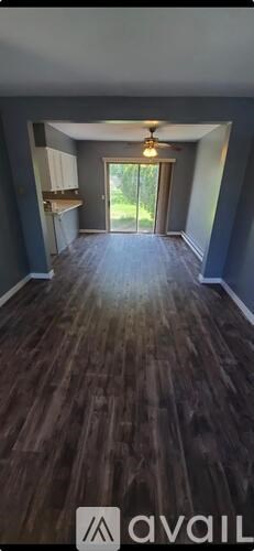 A room with wooden flooring and a ceiling fan.