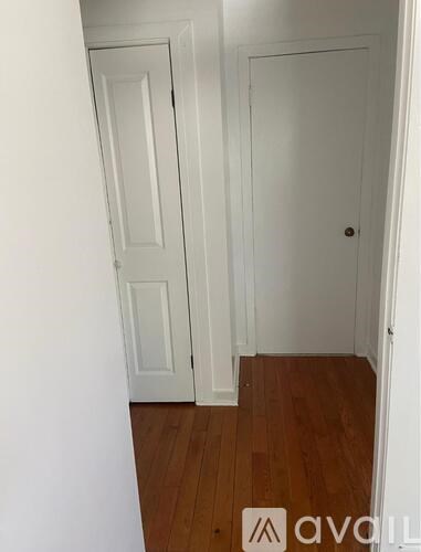 A room with two doors and wooden floors.