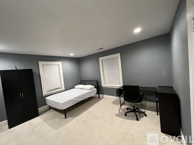 A bedroom with a bed, desk, and chair.