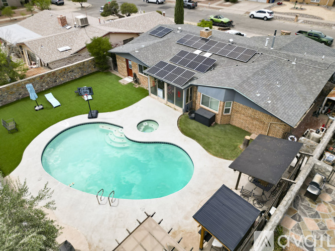 A house with a pool and solar panels on the roof.