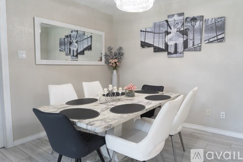A dining room with a marble table and chairs.