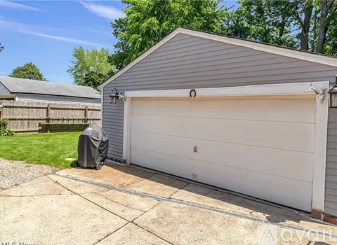 A garage with a white door is covered with a grey tarp.