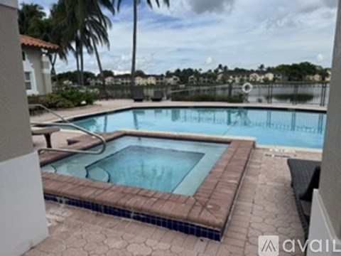 A pool with a brown tile border and a black bench.