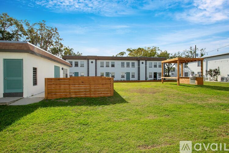 A grassy area in front of a building with a wooden fence.