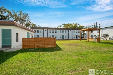 A grassy area in front of a building with a wooden fence.