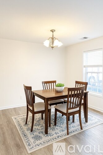 A dining room with a table and chairs.