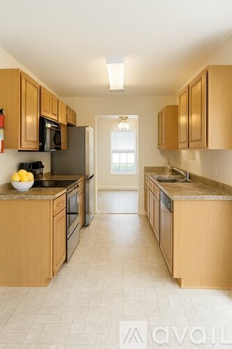 A kitchen with wooden cabinets and a tiled floor.
