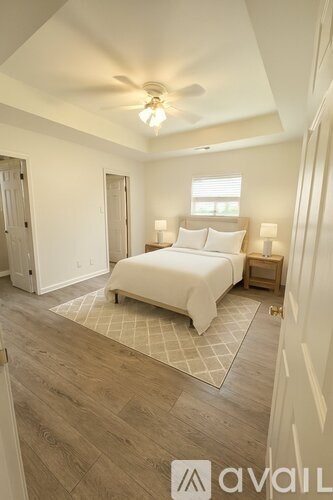 A bedroom with a bed, nightstands, and a ceiling fan.
