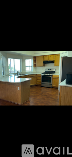 A kitchen with wooden cabinets and a stove top oven.