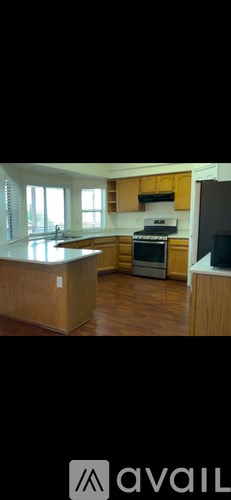 A kitchen with wooden cabinets and a stove top oven.