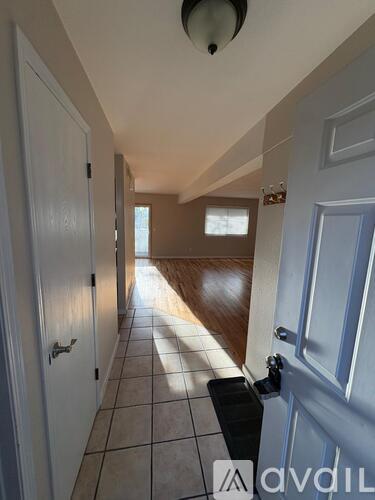 A hallway with a tiled floor and white doors.