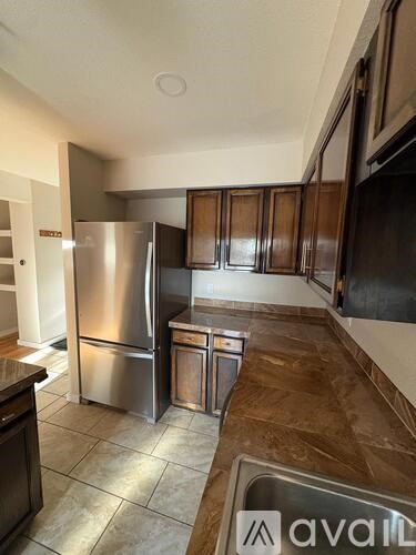 A kitchen with a stainless steel refrigerator and a sink.