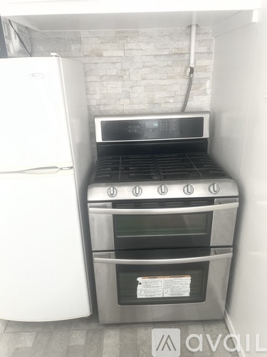 A white refrigerator is next to a stove in a kitchen.