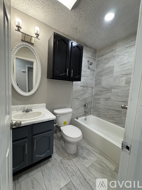 A bathroom with a sink, toilet, and bathtub.