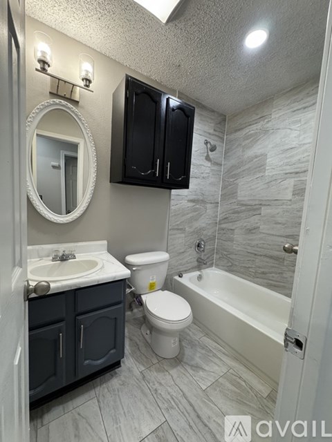 A bathroom with a sink, toilet, and bathtub.