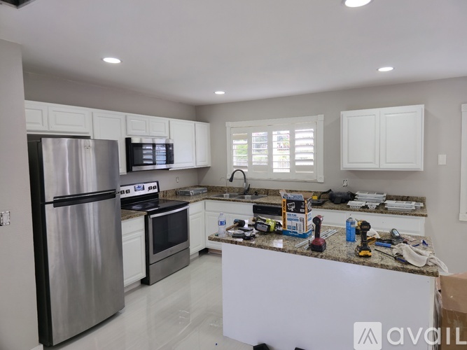 A kitchen with white cabinets and stainless steel appliances.