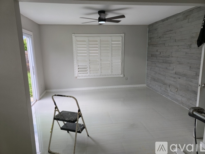 A room with a ceiling fan and a chair.