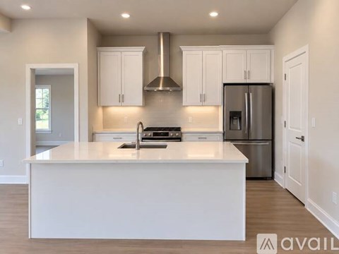 A modern kitchen with white cabinets and a stainless steel refrigerator.