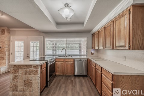 A kitchen with wooden cabinets and a stone counter.