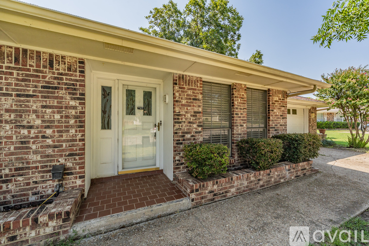 A house with a white door and a brick wall.