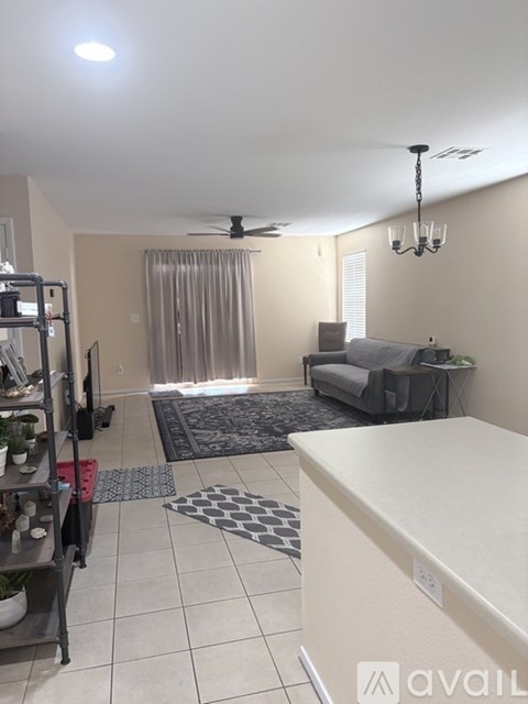 A living room with a grey couch and a black and white rug.