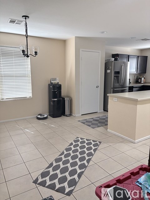 A kitchen area with a refrigerator, microwave, and a dining table.