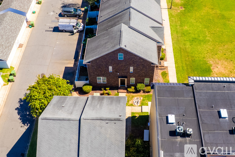 A house with a brown roof and a blue garage door is surrounded by other houses.
