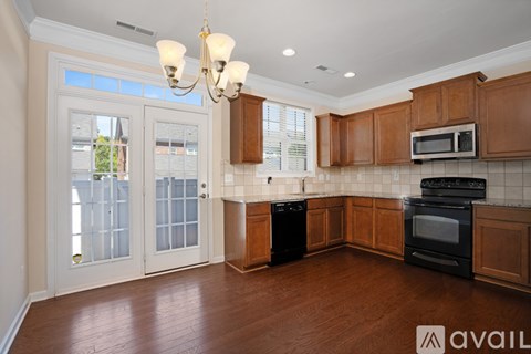 A kitchen with wooden cabinets and black appliances.