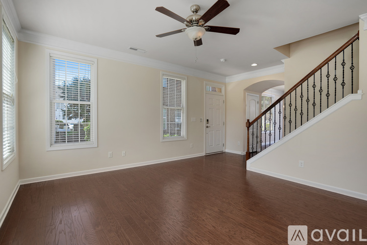 A spacious room with a ceiling fan and wooden flooring.