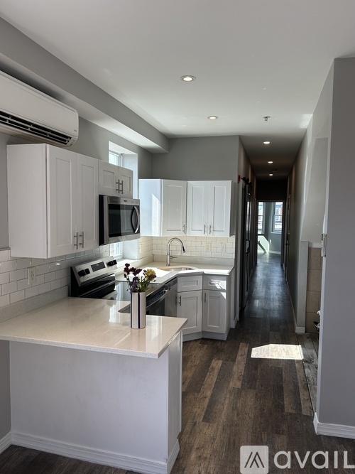 A kitchen with white cabinets and a white island.
