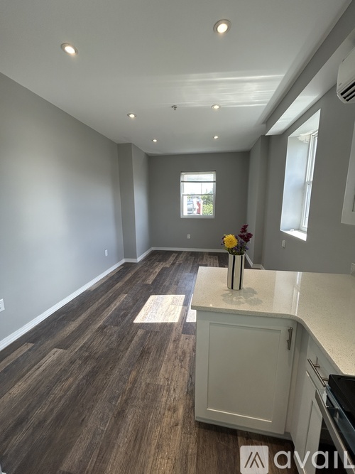 A kitchen with a wooden floor and white walls.