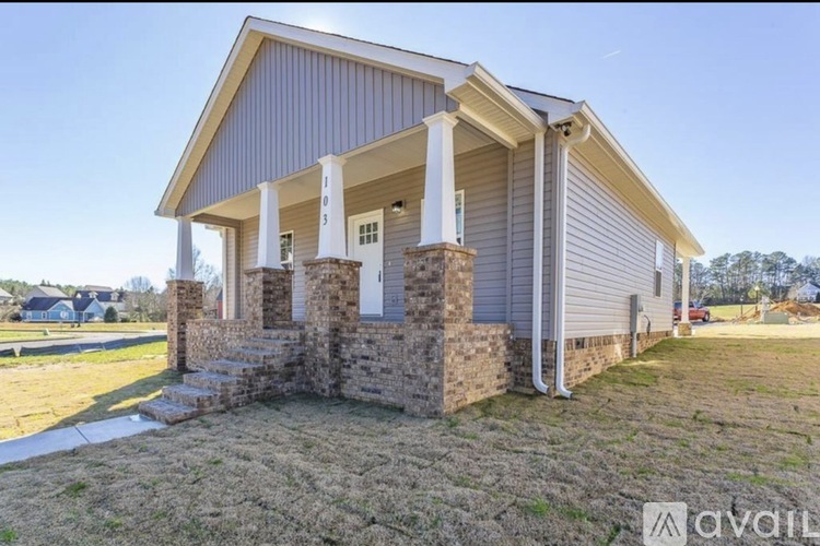A house with a porch and a stone pillar.
