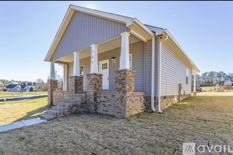 A house with a porch and a stone pillar.